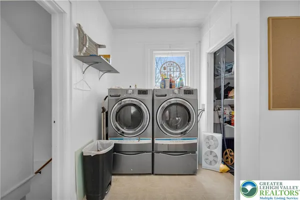 a utility room with dryer washer and a view of kitchen
