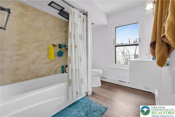 a bathroom with a tub toilet and window