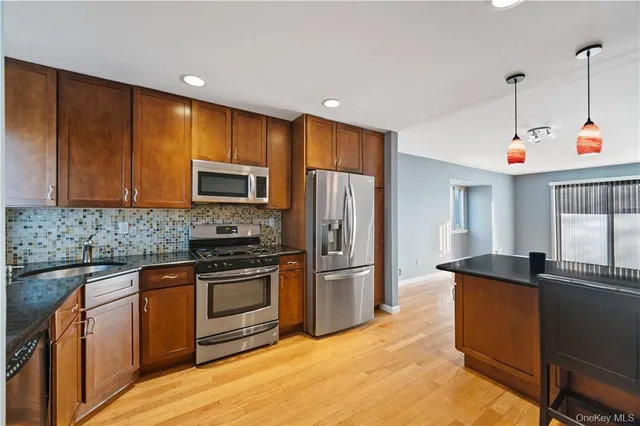 a kitchen with granite countertop a sink cabinets and stainless steel appliances
