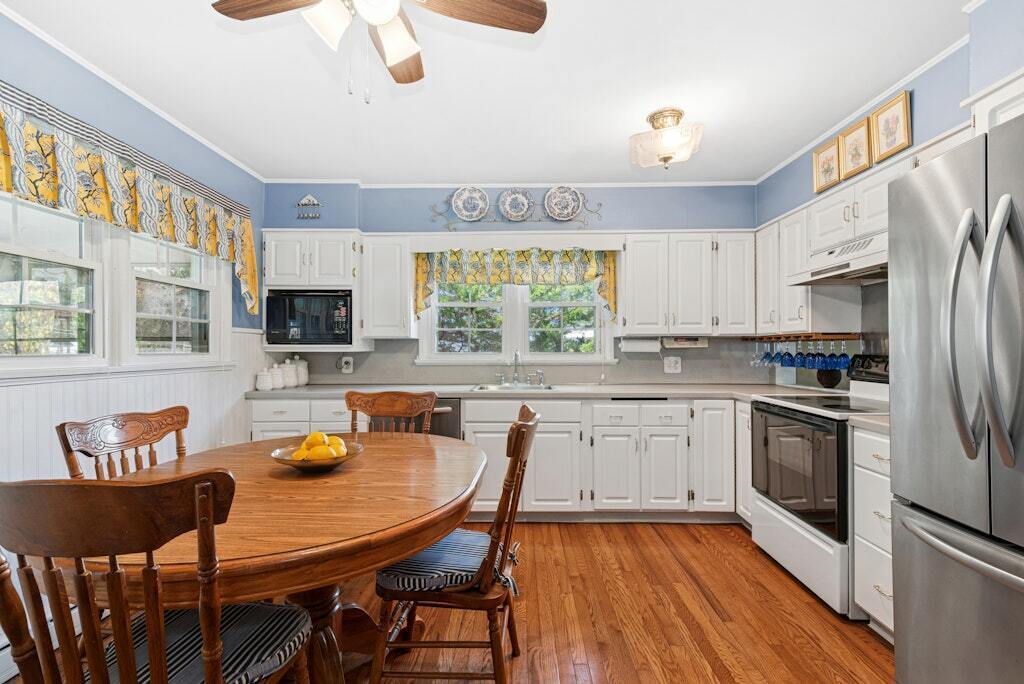 186 Hubbell Avenue Waterbury, CT 06708 - Photo 7 of 20 a kitchen with stainless steel appliances granite countertop a stove a refrigerator a kitchen island a dining table and chairs with wooden floor