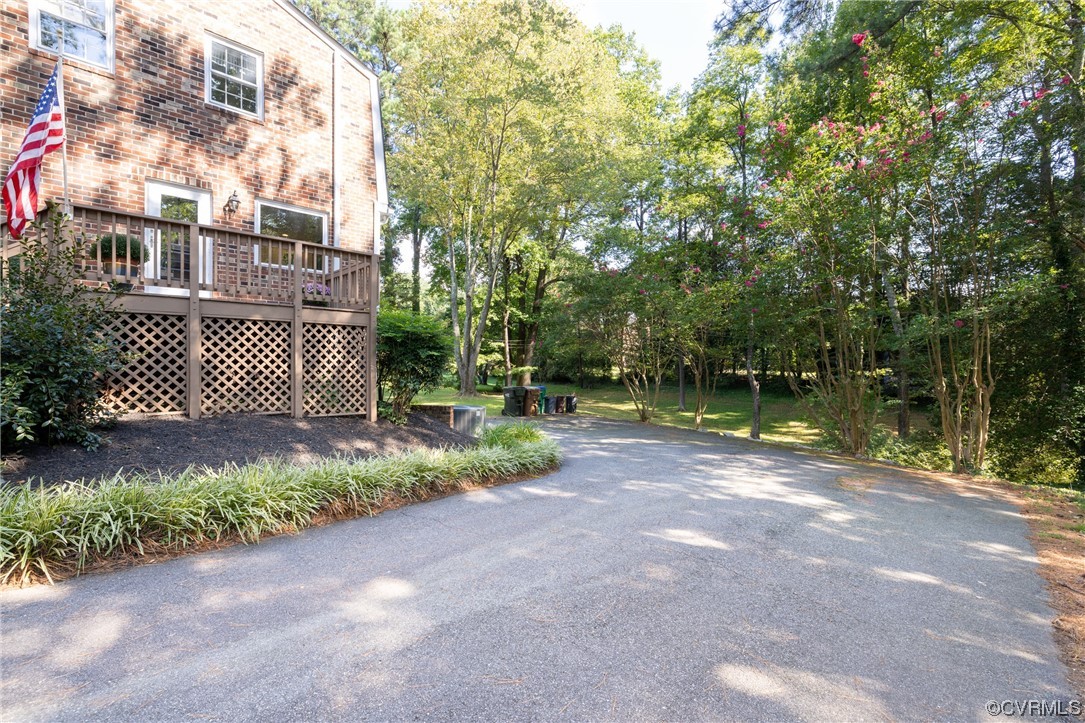 10163 Garfield Road Richmond, VA 23235 - Photo 3 of 44 a view of a yard with plants and a bench