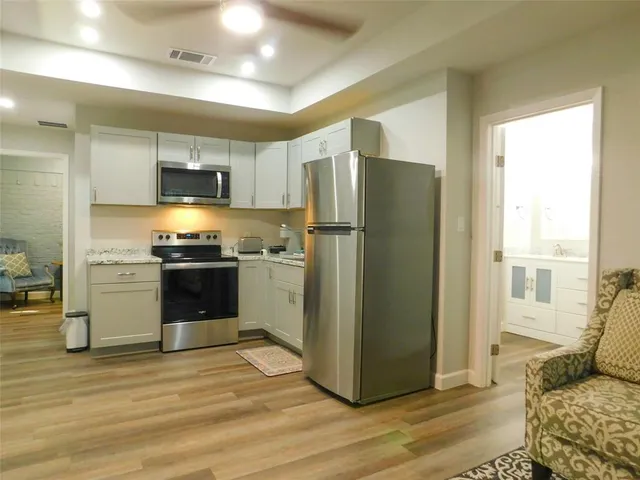 a kitchen with a refrigerator cabinets and wooden floor