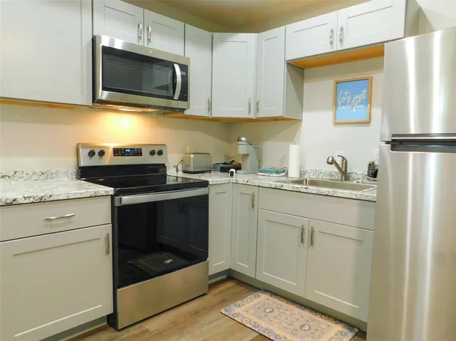 a kitchen with a sink stove and microwave
