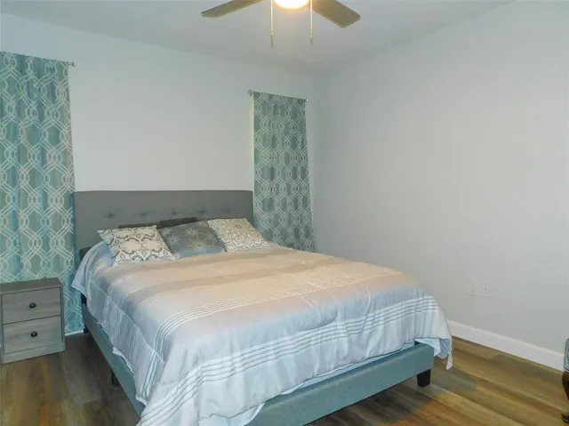 a bedroom with a bed and a chandelier fan
