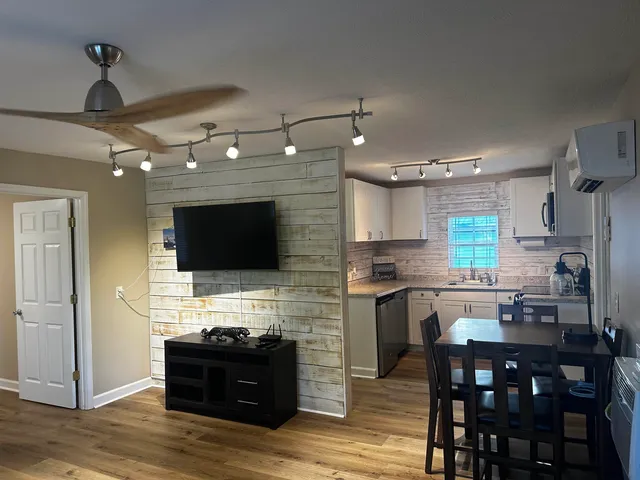 a living room with stainless steel appliances kitchen island granite countertop furniture a fireplace and a flat screen tv