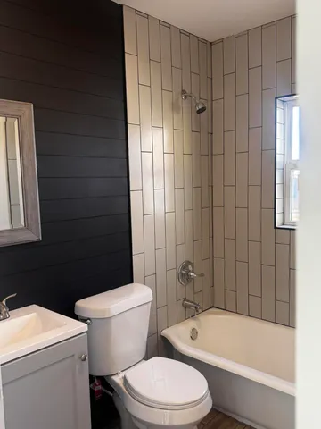 a white toilet and tub sitting next to a bathroom sink