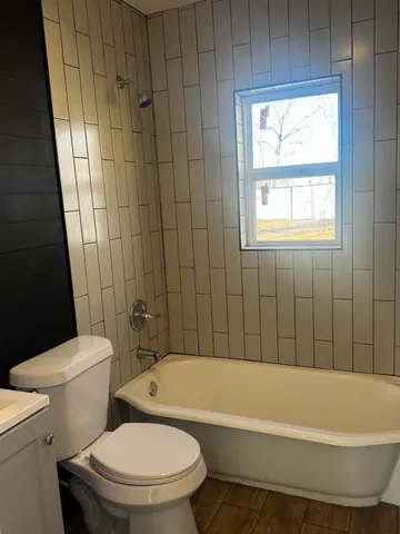 a bathroom with a toilet bathtub and window