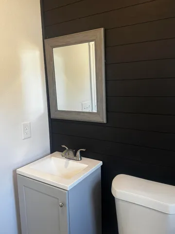 a bathroom with a sink a toilet and a mirror