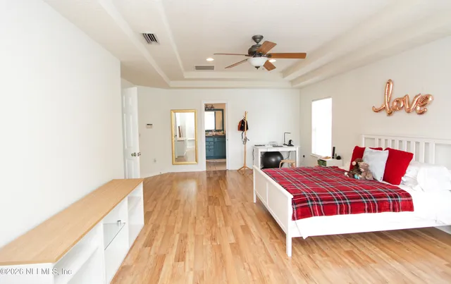 a spacious bedroom with a bed and a chandelier