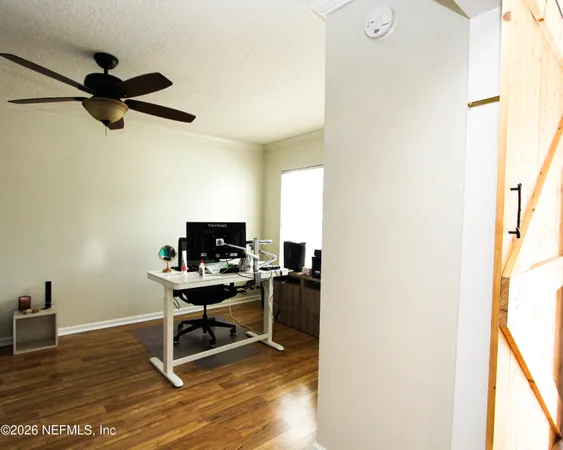a view of a workspace with furniture and a window