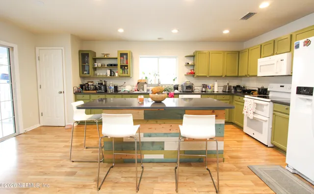 a kitchen with granite countertop a stove a sink and a refrigerator