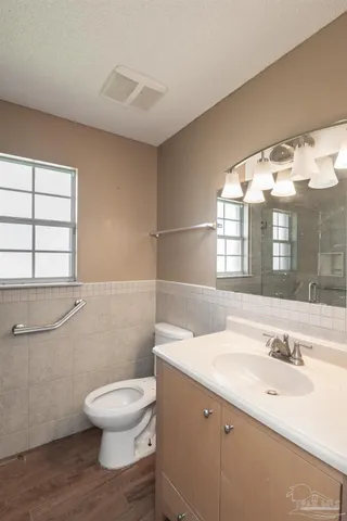 a bathroom with a toilet a sink and mirror