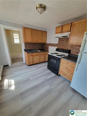 a kitchen with granite countertop a stove and a sink
