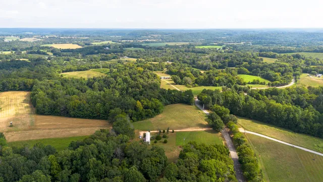 an aerial view of residential houses with outdoor space and trees