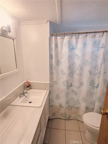 a bedroom with a bed and a refrigerator