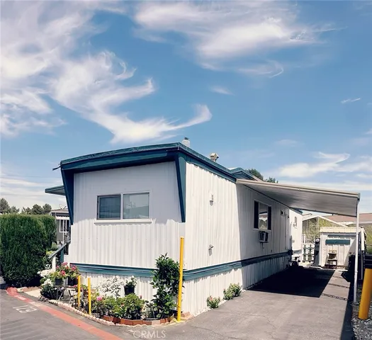a view of a backyard with chair and flower plants
