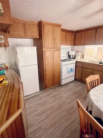 a kitchen with a dining table chairs and view of living room
