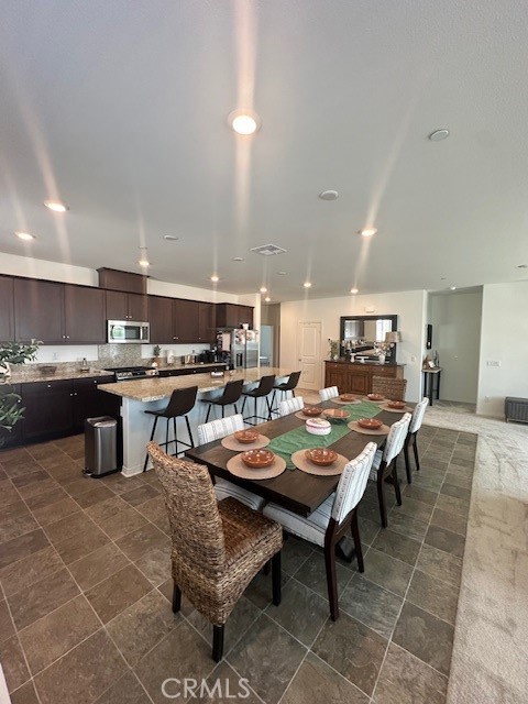 5233 Saloon Street Hemet, CA 92545 - Photo 15 of 28 a room with stainless steel appliances lots of wooden furniture a dining table and chairs