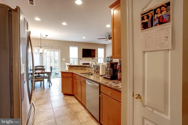 a kitchen with stainless steel appliances granite countertop sink refrigerator and cabinets