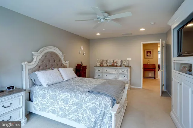 a spacious bedroom with a large bed and a chandelier