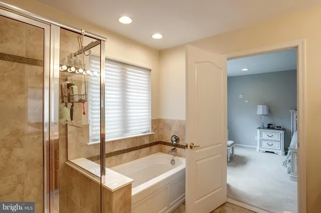 a bathroom with a tub a sink and mirror