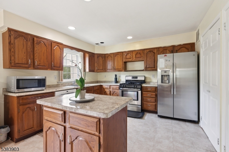 3606 Springbrook Drive Edison, NJ 08820 - Photo 13 of 25 a kitchen with kitchen island granite countertop stainless steel appliances a stove a sink a refrigerator cabinets and a center island