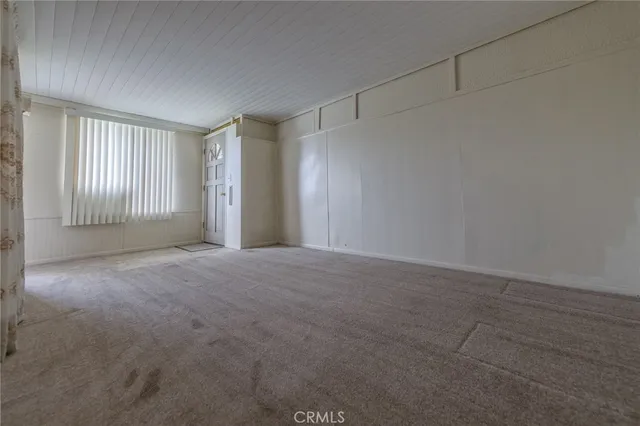 a view of a livingroom with an empty space and a window