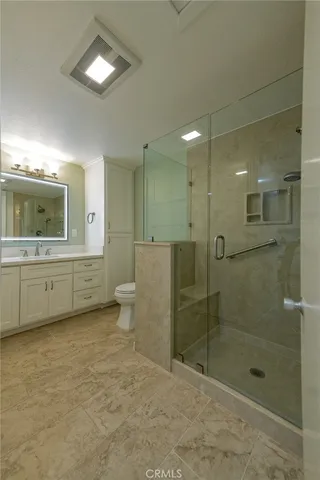 a bathroom with a double vanity sink toilet and shower
