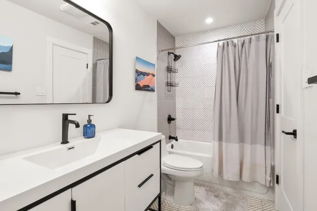 a bathroom with a sink a toilet and shower