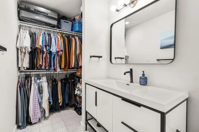 a view of walk in closet with clothes and shoes
