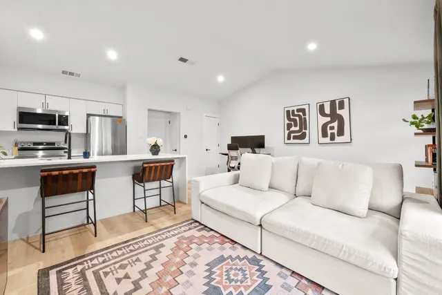 a living room with furniture and kitchen view