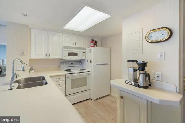 a kitchen with a refrigerator sink and white cabinets