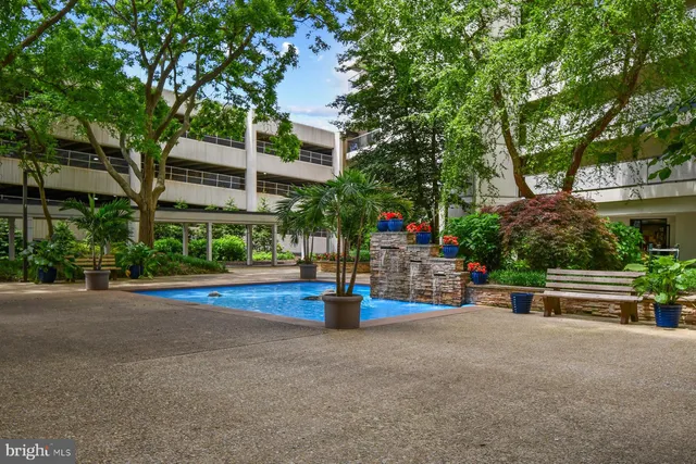 a view of street with flower plants and wooden fence