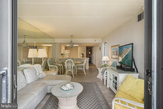 a living room with furniture a flat screen tv and a table