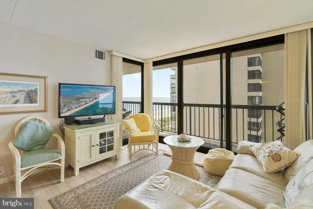 a living room with furniture and floor to ceiling windows