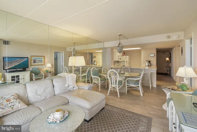 a living room with furniture a dining table and a chandelier