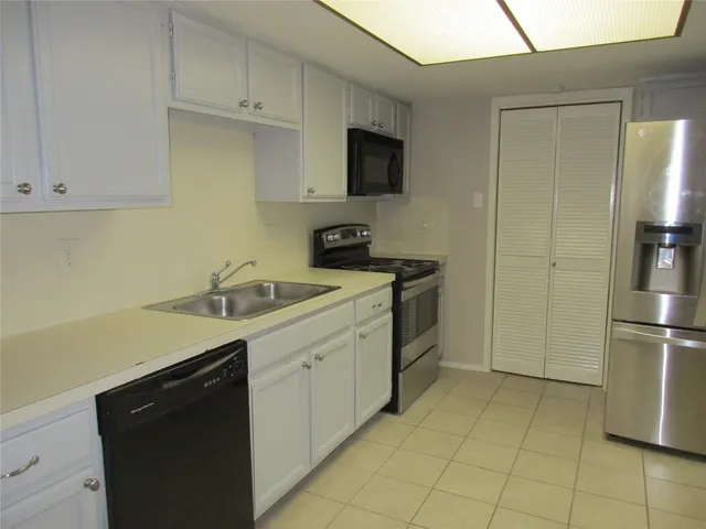 a kitchen with a sink cabinets and stainless steel appliances