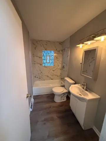 a bathroom with a white tub shower sink and toilet