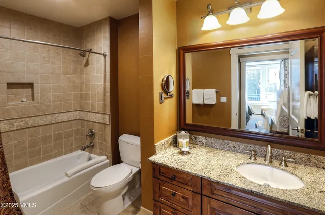 a bathroom with a granite countertop sink toilet and shower