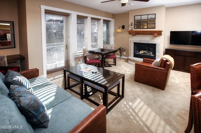 a living room with furniture a flat screen tv and a fireplace
