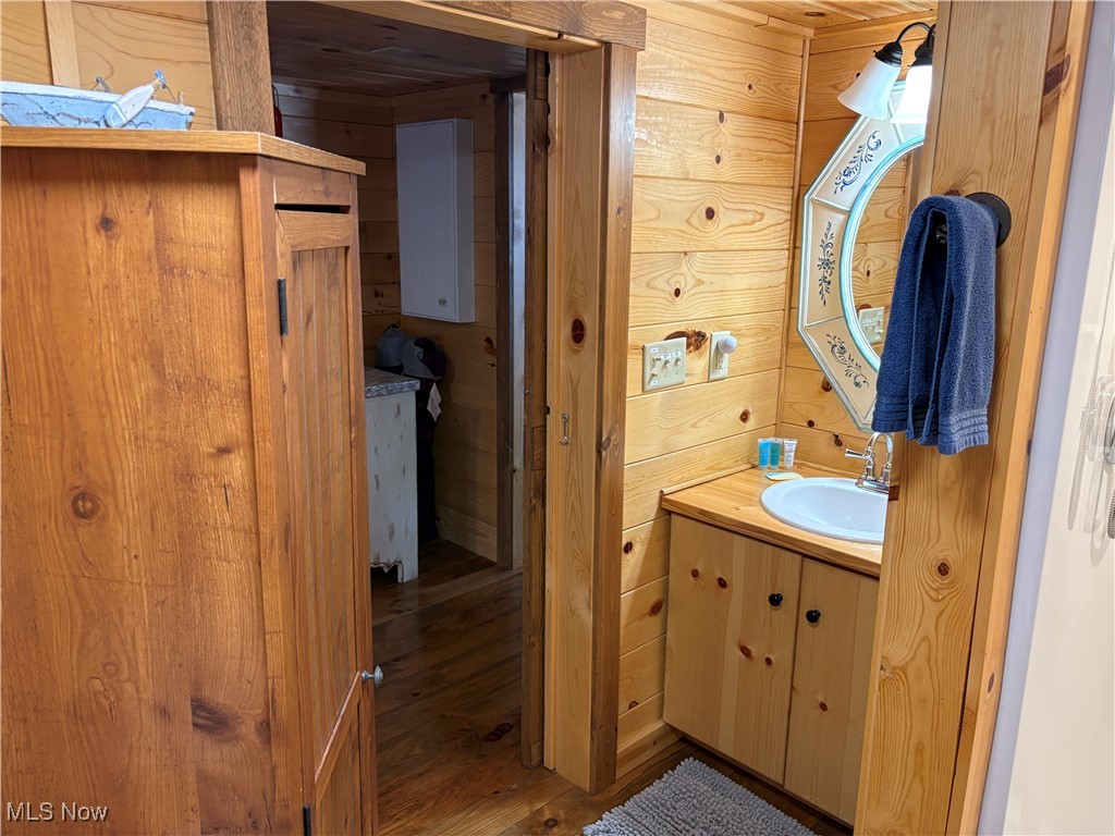 5919 Lake Road West, Unit 13 Ashtabula, OH 44004 - Photo 17 of 35 Bathroom with wood walls, vanity, and wood finished floors