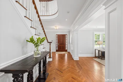 a hallway with wooden floor and furniture