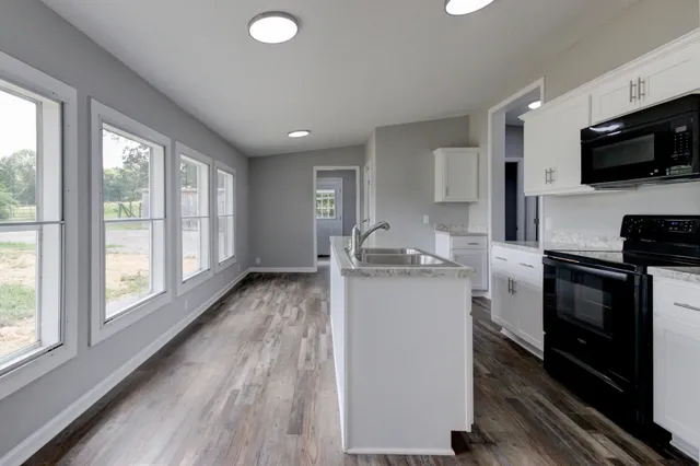 a kitchen with stainless steel appliances granite countertop a sink stove and cabinets