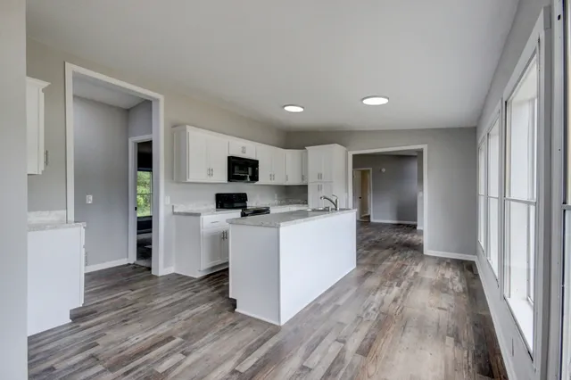 a kitchen with cabinets and wooden floor