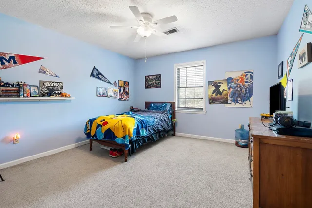 a bedroom with furniture and a flat screen tv