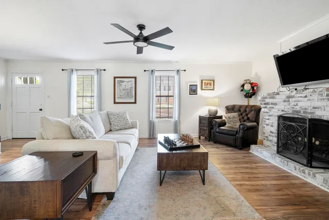a living room with furniture a flat screen tv and a fireplace