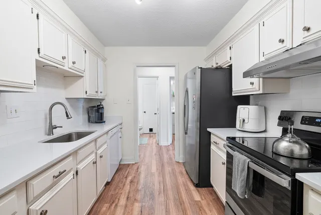 a kitchen with stainless steel appliances granite countertop a sink stove and refrigerator