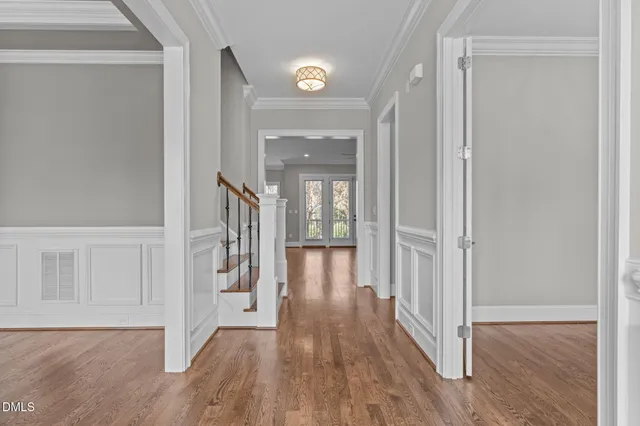 a view of a hallway with wooden floor and staircase