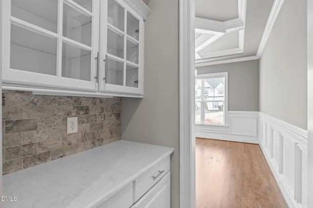 an empty room with wooden floor a fireplace and windows