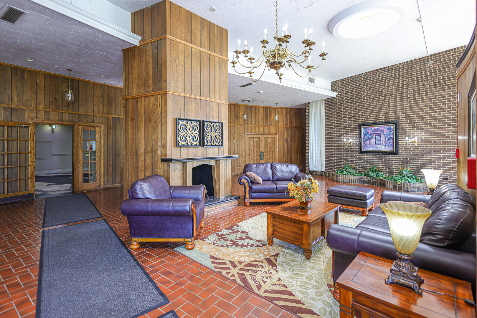 40 North Tower Road, Unit 1E Oak Brook, IL 60523 - Photo 2 of 15 a living room with furniture a fireplace and a chandelier
